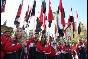 Người dân Syria mang quốc kỳ trên đường phố khi những chiếc quan tài của 27 nạn nhân thiệt mạng trong 2 vụ đánh bom hôm (17/3) được đưa tới nhà thờ Othman sau tang lễ của họ tại Damascus vào ngày 18/ 3/2012. (Ảnh: Getty Images)